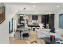 Open-concept living space featuring a dining area, cozy sofas, modern lighting, and a view into the kitchen at 2921 Newton St, Denver, CO 80211