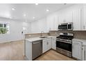Modern kitchen boasts stainless steel appliances, white cabinetry, and lots of natural light at 17123 W 91St Ln, Arvada, CO 80007