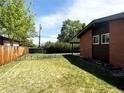 This backyard features an enclosed yard and lush green grass on a bright sunny day at 5722 W Chestnut Ave, Littleton, CO 80128