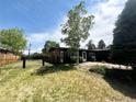 This property is surrounded by an enclosed yard with lush grass and mature trees at 5722 W Chestnut Ave, Littleton, CO 80128