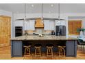 Gourmet kitchen features an expansive island, stainless steel appliances, pendant lights, and counter seating at 14370 Osage St, Westminster, CO 80023