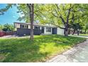 Inviting home exterior with a lush front lawn and mature trees providing ample shade and curb appeal at 4854 S Parfet St, Littleton, CO 80127