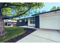Attractive home with a modern painted exterior, a well-kept lawn, and a concrete driveway at 4854 S Parfet St, Littleton, CO 80127