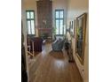 Open-concept living room with hardwood floors, a brick fireplace, and large windows for ample natural light at 14131 E Baltic Pl, Aurora, CO 80014