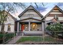 Charming grey two-story home with a cozy front porch and vibrant orange front door at 2244 N Washington St, Denver, CO 80205