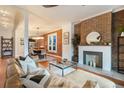 Stylish living room with exposed brick wall, fireplace, and open floor plan to dining area at 2244 N Washington St, Denver, CO 80205