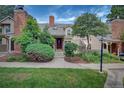 Inviting townhome exterior featuring a brick chimney, well-maintained lawn, and a private patio at 2713 W Long Dr # C, Littleton, CO 80120