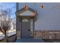 Inviting front entrance featuring a gray door with decorative glass and stone accents, creating a welcoming first impression at 3260 E 103Rd Pl # 912, Thornton, CO 80229