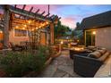 Inviting backyard patio with pergola, string lights, and cozy seating around a fire pit at 848 S Emerson St, Denver, CO 80209