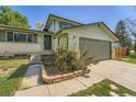 Exterior view of a home with neutral siding, a front garden, and an attached garage at 16623 E Asbury Pl, Aurora, CO 80013