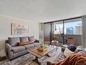 Cozy living room with balcony access and stunning cityscape views at 1020 15Th St # 24H, Denver, CO 80202