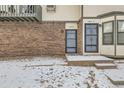 Close-up of townhome entrances featuring brick exterior, secure doors and snowy walkways at 1760 S Ammons St # D, Lakewood, CO 80232