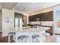 Modern kitchen with stainless steel appliances, a granite island, and dark wood cabinets at 8460 E 54Th Dr, Denver, CO 80238