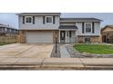 Charming two-story home featuring an attached two-car garage, well-maintained lawn, and inviting entryway at 450 Lone Pine St, Fort Lupton, CO 80621
