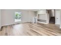 Bright and spacious living area featuring light hardwood floors, a large window and built in shelves at 450 Lone Pine St, Fort Lupton, CO 80621
