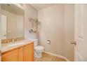 Cozy half bathroom with decorative shelves, modern toilet, and a granite countertop vanity at 10061 Apollo Bay Way, Highlands Ranch, CO 80130