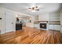 Bright living room featuring hardwood floors, fireplace, and built-in shelving at 7038 Otis Ct, Arvada, CO 80003