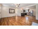 Open concept living room with hardwood floors and a view into the kitchen at 7038 Otis Ct, Arvada, CO 80003