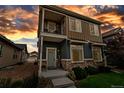 Charming two-story home featuring stone accents, a cozy front porch, and welcoming curb appeal set against a vibrant sky at 4589 Quandary Peak St, Brighton, CO 80601
