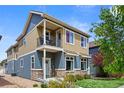 Charming two-story home with a cozy front porch and well-manicured lawn on a sunny day at 4589 Quandary Peak St, Brighton, CO 80601