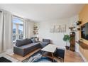 Bright living room featuring a comfortable gray sofa, large arched window, and stylish decor at 1629 S Deframe St # B8, Lakewood, CO 80228