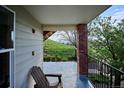 Covered patio with wood chair that offers a private outdoor space with views of lush greenery at 1629 S Deframe St # B8, Lakewood, CO 80228