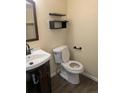 Bathroom featuring modern sink, toilet, and black shelving at 15703 E 13Th Pl, Aurora, CO 80011