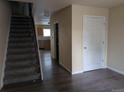 Inviting entryway with wood-look flooring, staircase, and access to the kitchen at 15703 E 13Th Pl, Aurora, CO 80011