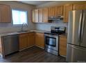 Updated kitchen with stainless steel appliances, granite countertops, and wood cabinets at 15703 E 13Th Pl, Aurora, CO 80011