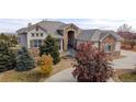 Stunning home showcasing stone accents, mature landscaping, and a circular driveway at 6425 Tremolite Dr, Castle Rock, CO 80108