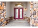 Elegant front entrance featuring double doors, stone accents, and transom window at 6425 Tremolite Dr, Castle Rock, CO 80108
