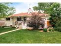 Charming, white-painted home with a red roof, covered porch and meticulous landscaping at 5885 S Huron St, Littleton, CO 80120