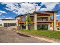 Beautiful exterior featuring stone accents, a covered balcony, and a spacious driveway with ample parking at 5820 Powell Rd, Parker, CO 80134