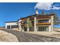 Contemporary home with stone and wood accents, and a large driveway at 5820 Powell Rd, Parker, CO 80134