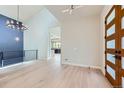Bright foyer with hardwood floors, modern lighting, and a stylish front door at 5820 Powell Rd, Parker, CO 80134