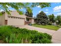 Landscaped front yard with mature trees and a driveway leading to the attached garage at 4994 S Independence Way, Littleton, CO 80123
