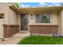 Close-up of the front door with brick accents and well maintained greenery at 4994 S Independence Way, Littleton, CO 80123