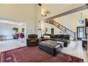 Open-concept living room with high ceilings, a staircase, and comfortable leather seating at 17076 Foxton Dr, Parker, CO 80134