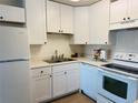 Well-lit kitchen boasts white cabinets, a stainless steel sink, and modern appliances at 755 S Alton Way # 12C, Denver, CO 80247