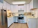 Bright kitchen featuring stainless steel appliances, white cabinetry, and ample countertop space at 755 S Alton Way # 12C, Denver, CO 80247