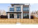 Contemporary home showcasing mixed materials, large windows, and a fenced front yard at 2720 N Saint Paul St, Denver, CO 80205