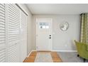 Bright foyer featuring hardwood floors, a coat closet, and modern decor at 11278 Clermont Dr, Thornton, CO 80233