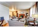 Spacious living room with large sofas, a brick fireplace, and plush decor creates a comfortable atmosphere at 233 Nome St, Aurora, CO 80010