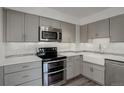 The remodeled kitchen includes stainless steel appliances and gray cabinets at 460 S Marion Pkwy # 706, Denver, CO 80209