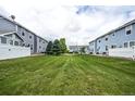 A large backyard area between two rows of townhomes featuring well-kept green grass at 19249 E 58Th Ave # D, Denver, CO 80249