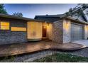 Exterior shot showcasing the unique curved glass-block window and the home's front door at 5461 S Youngfield Ct, Littleton, CO 80127