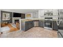 Modern kitchen with granite countertops, stainless steel appliances, and views of the living space at 1716 W Sunset St, Longmont, CO 80501