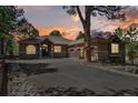 A single Gathering house with stone and stucco accents, long paved driveway, and manicured landscaping at sunset at 670 Independence Dr, Larkspur, CO 80118