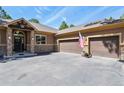 A beautiful two-car garage with stone accents and a pristine paved driveway at 670 Independence Dr, Larkspur, CO 80118