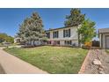 Two-story home featuring a well-maintained lawn, mature trees, and easy access to backyard at 15531 E Jewell Pl, Aurora, CO 80013